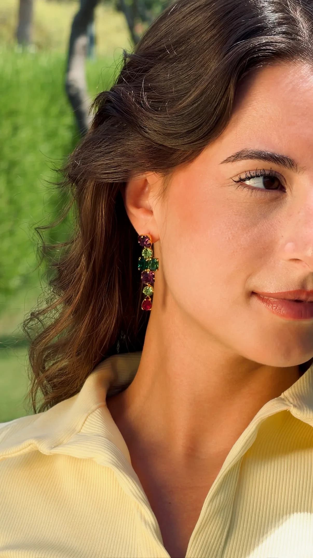 Model in profile wearing a long crystal drop earring